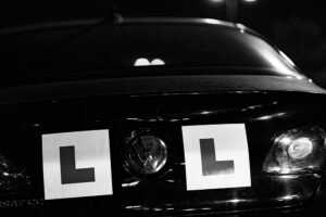 Two learner driver L-plates on the back of a car at night, one on each side of the badge. Building habits that don’t last is a learning process.